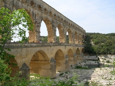 This is a photograph of a Roman insula. aqueduct. bridge. coliseum.-example-1