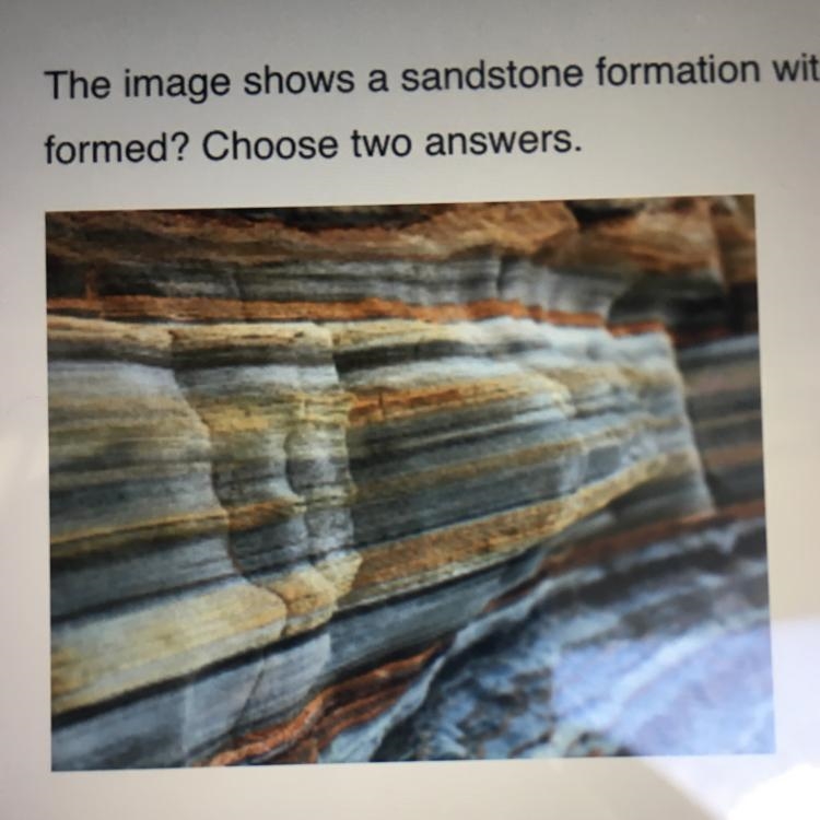 The image shows a sandstone formation with visible bands of different colors. What-example-1