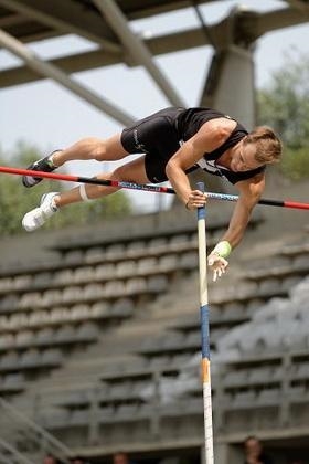 A pole vaulter runs forward, plants his pole, rises in the air and lands. What point-example-1