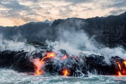 This image shows a volcanic eruption in Hawaii with lava flowing into the sea. Which-example-1