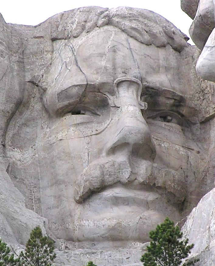 Which president depicted on mount rushmore is wearing glasses-example-1