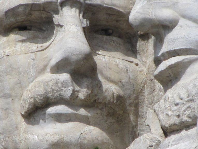 Which president depicted on mount rushmore is wearing glasses-example-3