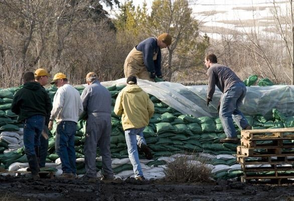 The image below shows people using sandbags as a means to contain a rapidly rising-example-1