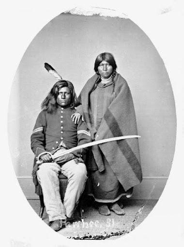 Why does the Pawnee warrior Loots-Tow-Oots hold a sword in the photograph taken of-example-1