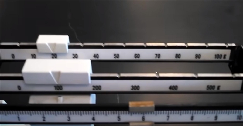 What is the mass of the object being measured? A triple beam balance is shown. The-example-1