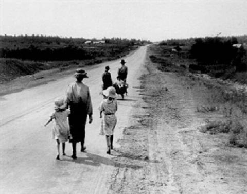 Which mood does the grayscale color scheme of Dorothea Lange's Homeless Family convey-example-1