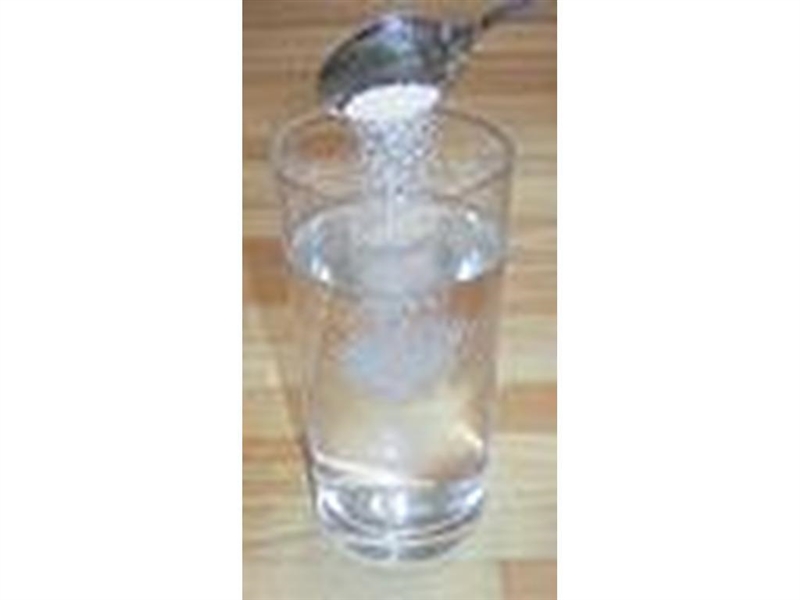 The picture shows a spoonful of salt being added to a glass of water. What physical-example-1