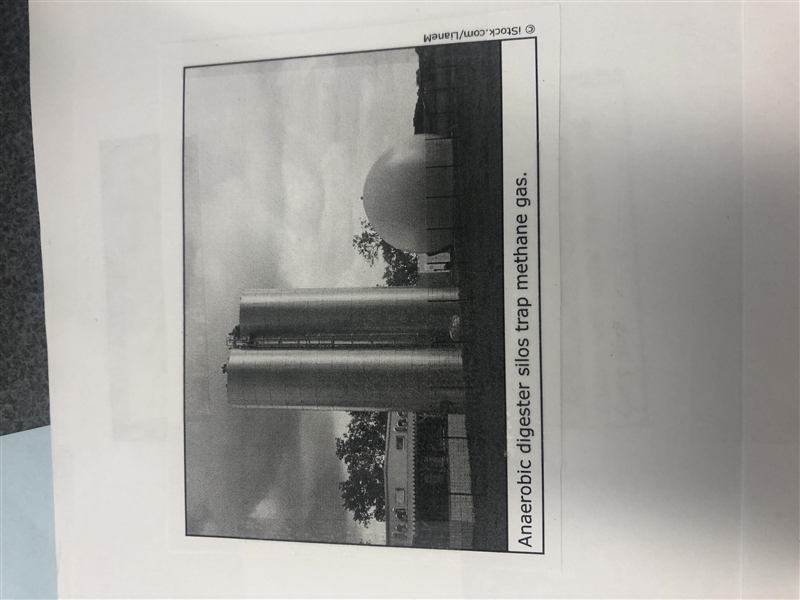 What does the photograph of the anaerobic digester silos and its caption help the-example-1