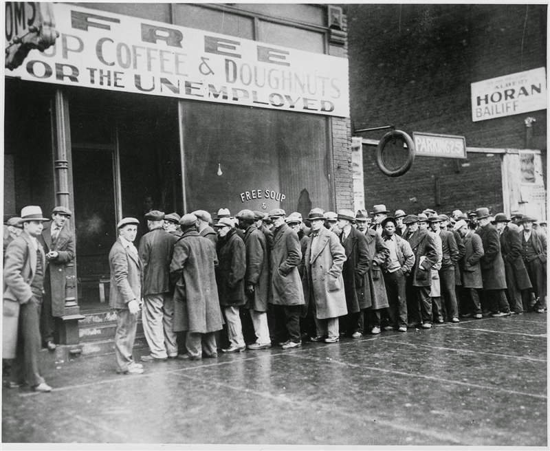 The photo shows men waiting in line for free bread and soup. Who was most likely responsible-example-1