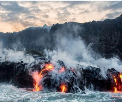 This image shows a volcanic eruption in Hawaii with lava flowing into the sea. Which-example-1