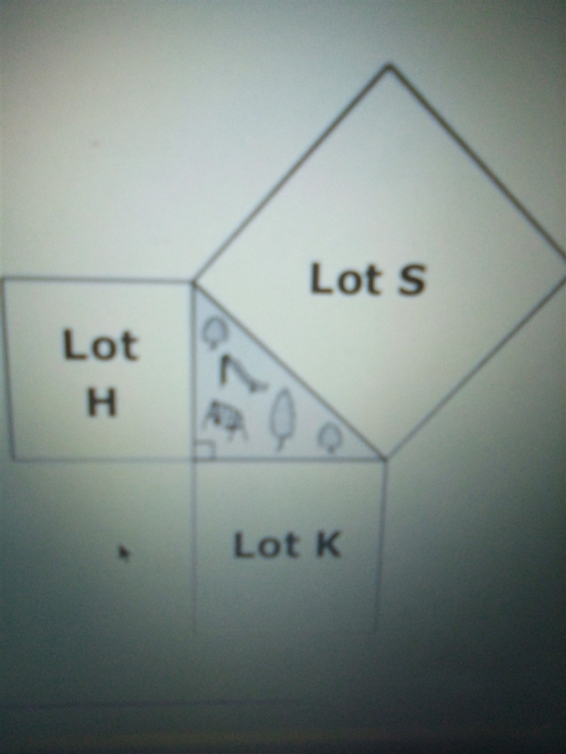 a drawing shows three squares parking lots that enclose a grassy area shaped like-example-1