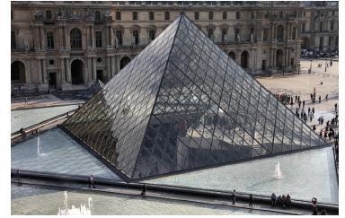 The entrance to the Louvre Museum in Paris, France, is a square pyramid. The side-example-1