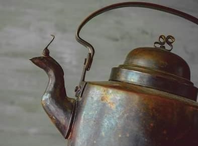 The photograph shows a kettle made of the element copper. Which statement describes-example-1